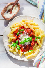 Closeup of homemade pasta penne with tomato sauce and basil