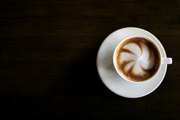 Cup of cappuccino art coffee with froth shape plumeria and woode
