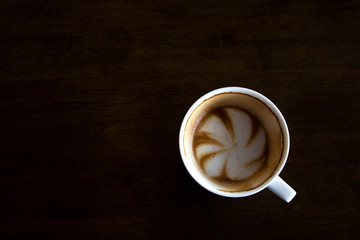Cup of cappuccino art coffee with froth shape plumeria and woode