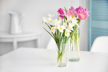 Beautiful tulips and irises on dinning table , indoors