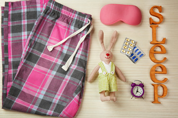 Insomnia concept. Sleeping accessories on light wooden table, top view