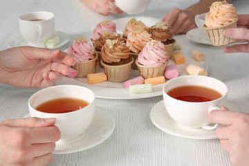 Tea Party with sweet creamy cakes over wooden table background