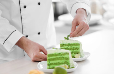 Male hands decorating cake slices with mint.