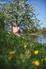 beautiful girl in dress sitting under the apple blossom