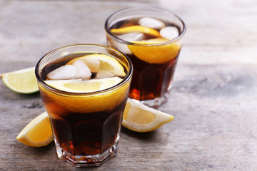 Glasses of soda water with sliced lemon on wooden table