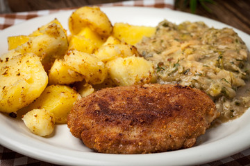Delicious meal of minced meat cutlet, potatoes and fried cabbage