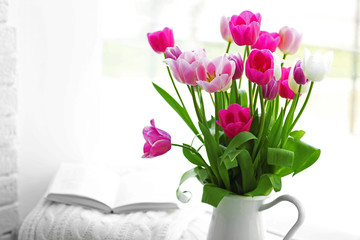 Beautiful fresh tulips on windowsill background