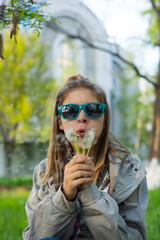 Young women blowing dandelion