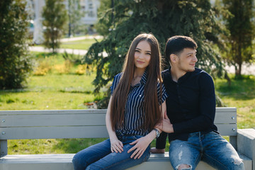 Naklejka premium Loving young calm beautiful couple sitting on the bench 