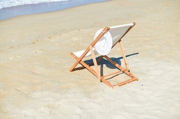 Fototapeta na wymiar Deckchair and female hat on stunning tropical beach vacation background