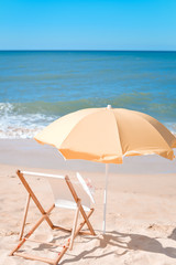 Sun parasol, chair longue and female hat on vacation beach sun shine 