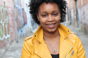 Beautiful young African girl smiling in an alley 