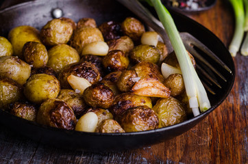 Roasted young potatoes in a pan with garlic. Selective focus. Toned image