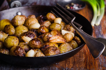 Roasted young potatoes in a pan with garlic. Selective focus. Toned image