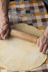 Cooking and home concept - close up of male hands kneading dough