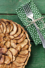 Juicy apple pie with cinnamon and brandy on a green background