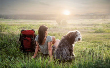 Frau mit Hund beim Sonnenuntergang