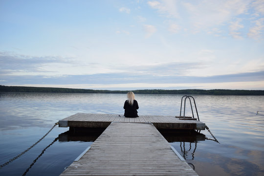 Young blonde woman with beautiful swedish landscape in the background