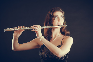 Woman playing transverse flute on black. © anetlanda