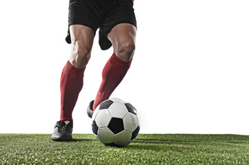 football player in red socks and black shoes running and dribbling with the ball playing on grass