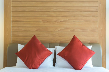 white bed sheet with red pillow