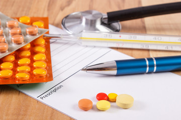 Medical pills, tablets or supplements with prescription, thermometer and stethoscope, health care concept