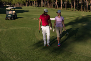 Obraz premium couple walking on golf course