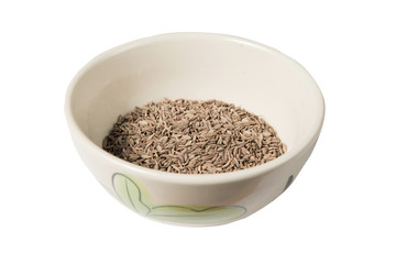 Isolated bowl of dried cumin seed on the white background