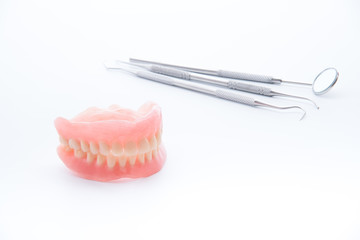 Denture and dental tools,dental mirror on white background