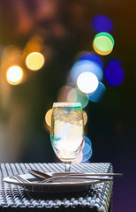 Glass of cold water with nightlife Bokeh lighting background