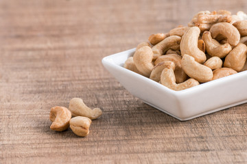 Roasted cashew nuts on wooden background