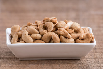 Roasted cashew nuts on wooden background