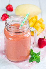 Healthy smoothie with strawberry, mango and banana in glass jar