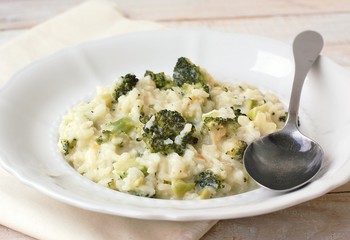 Creamy risotto with broccoli on the cloth and wooden background