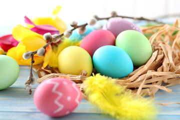 Fototapeta na wymiar Easter eggs in nest on a blue wooden table