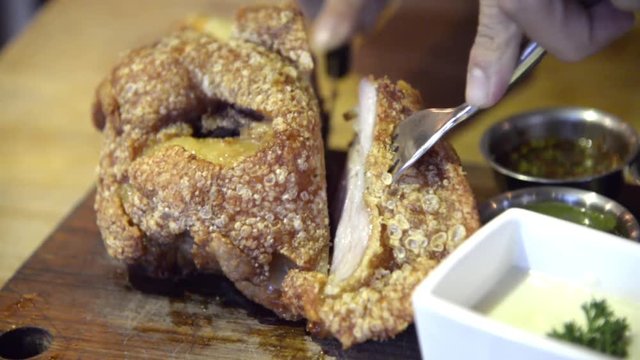 Unknown man eating fried German pork knuckle (eisbein) sliced with knife closeup long version full HD.