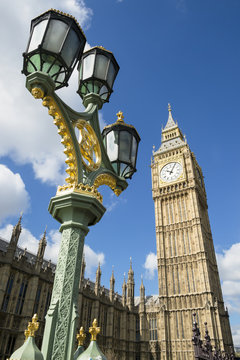Big Ben shines in bright morning sun behind a decorative lamppost at Westminster Palace London