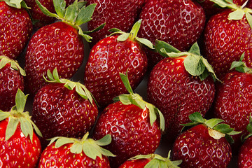 Strawberry background of whole strawberries.  Colorful ripe strawberries. Fruit background. Strawberry pattern. Spring, summer background. Macro. Texture.