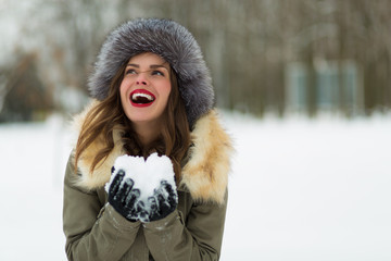 Beautiful woman in winter coat and fur hat © Tinatin