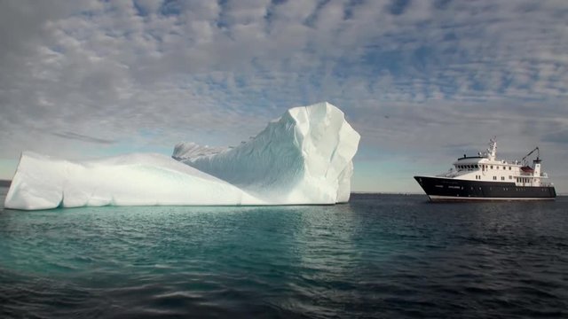 A large iceberg and the ship in the Arctic. Fantastic wonderful amazing video grenland nature iceland. Lovely shooting the life of nature, seaside and mountains. Global warming.
