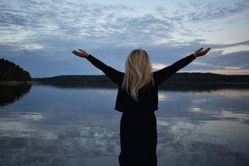 Young blonde woman with beautiful swedish landscape in the background