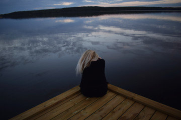 Fototapeta premium Young blonde woman with beautiful swedish landscape in the background
