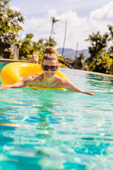 Sexy girl with yellow ring at pool party