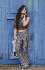 Fototapeta premium Hippie girl in front of bright blue door 