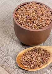Buckwheat groats on a wooden spoon.