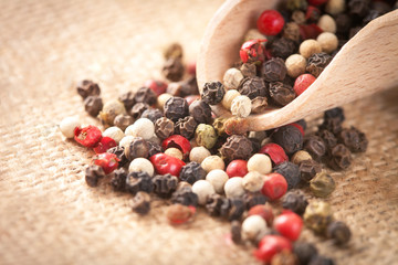 Red, white and black pepper in a spoon