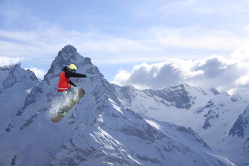 Snowboard rider jumping on mountains. Extreme snowboard freeride sport.