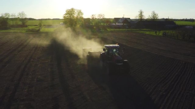 Farm tractor working in the field. Aerial footage. Slow motion.