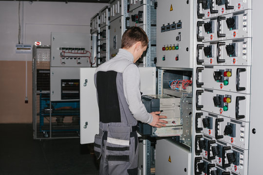 Electrician near the low-voltage cabinet. Uninterrupted power supply. Electricity.
