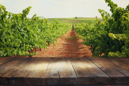 image of wooden table in front of Vineyard landscape